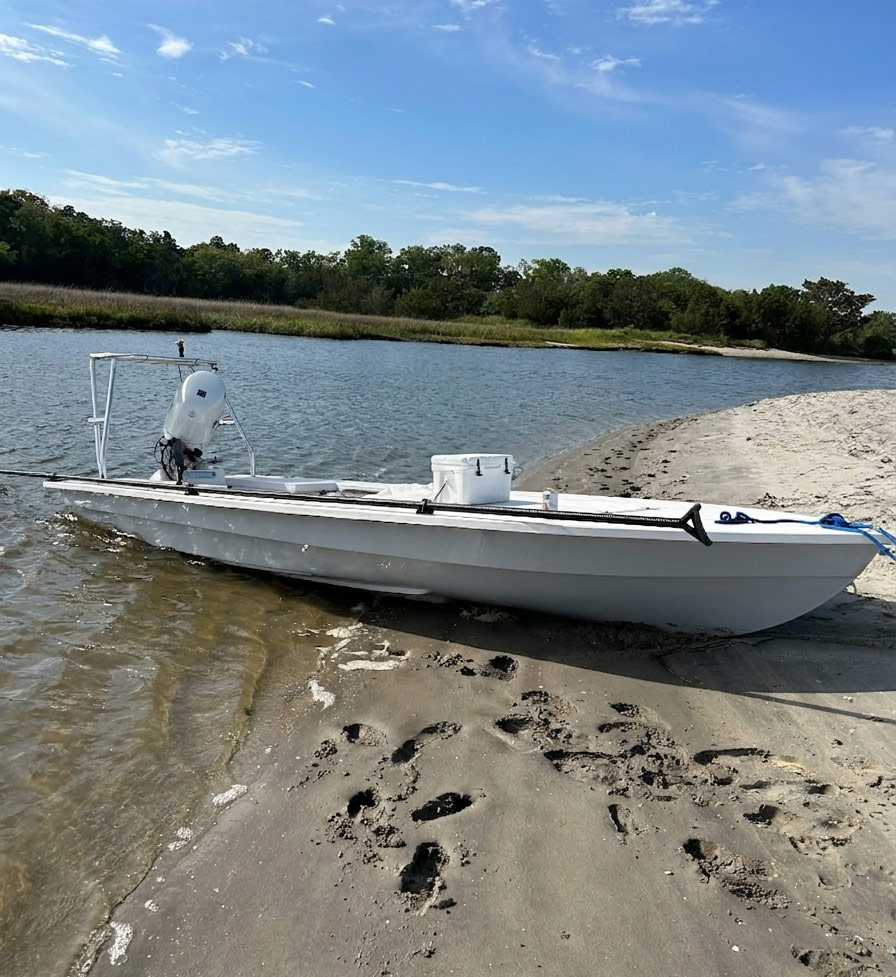 Lancha 18 skiff pulled onto a sandy shoreline
